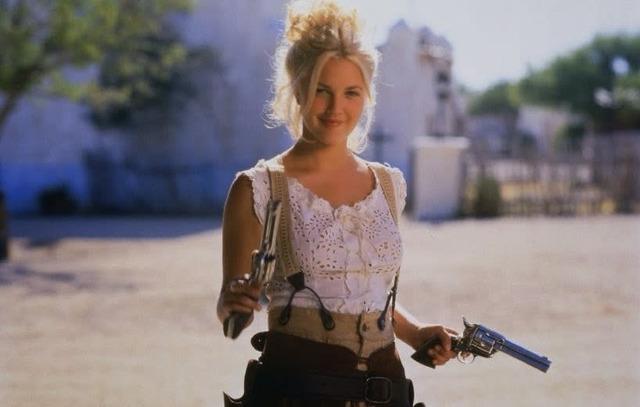 Drew Barrymore as Lilly Laronette, the youngest and most rebellious member of the Bad Girls gang, armed and ready for action.